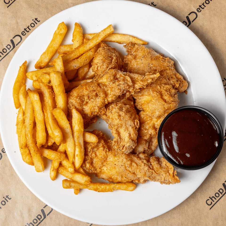 Crispy chicken tenders and golden french fries with a side of BBQ sauce on a white plate.