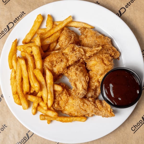 Crispy chicken tenders and golden french fries with a side of BBQ sauce on a white plate.